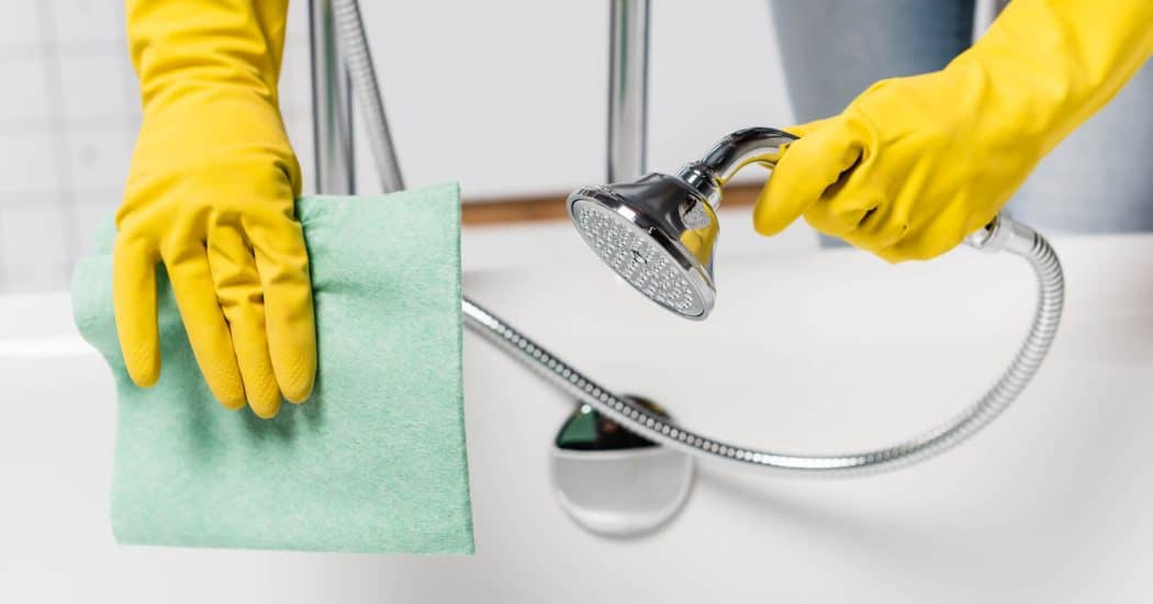 Cleaning a shower to help prevent mold in a New Orleans bathroom