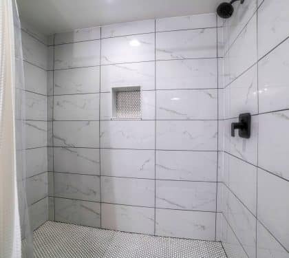 Walk-in shower with marble tile in a New Orleans bathroom