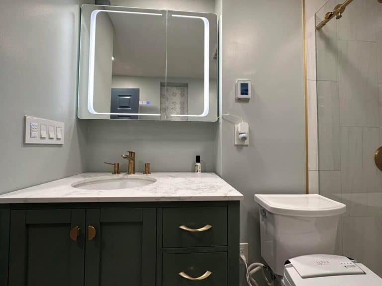 Sink with Mirror beside a toilet - Turnkey Bath Remodel