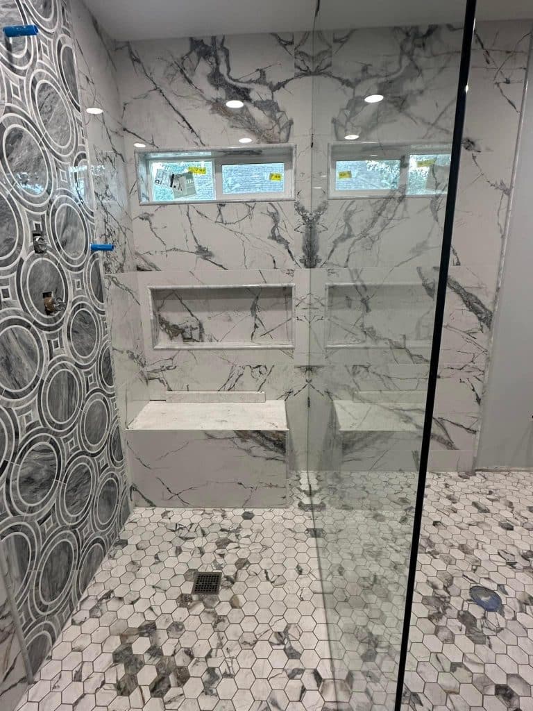 Walk-in shower with patterned tile and a glass enclosure in New Orleans