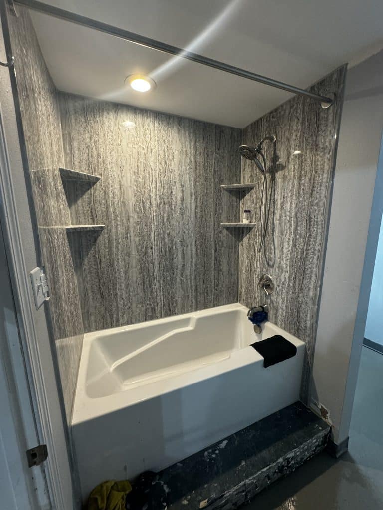Tub-and-shower combo with textured wall panels in a New Orleans bathroom