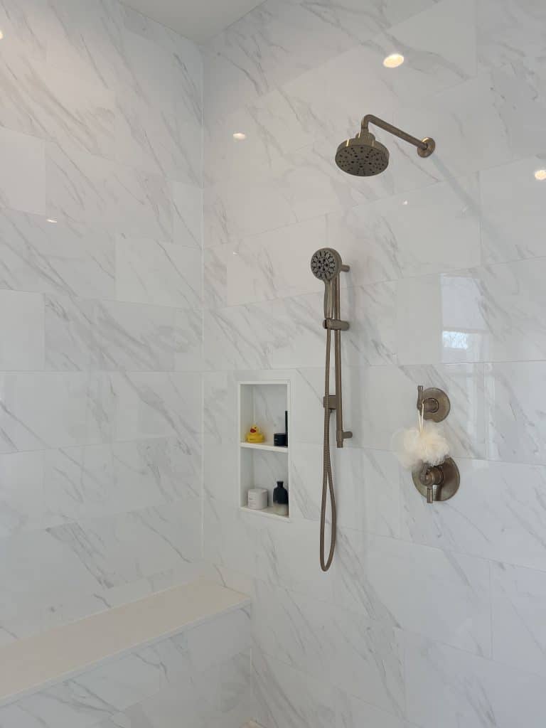 Marble tile walk-in shower with a rain shower head and handheld sprayer